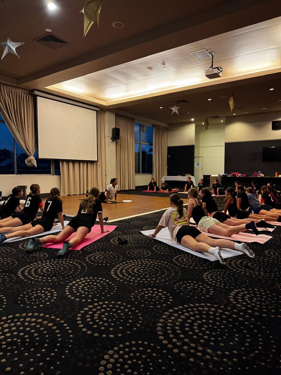 Young athletes practicing yoga with Yogi Club