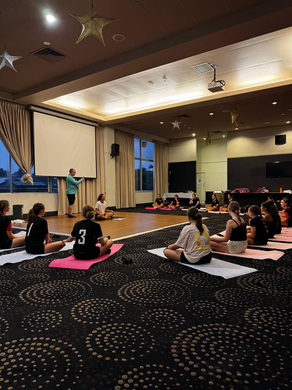 Giovana from Yogi Club leading a yoga session for a football team